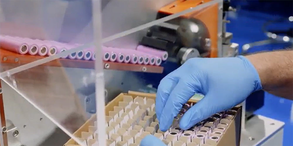 Cylindrical battery cells being sorted by an automated machine.