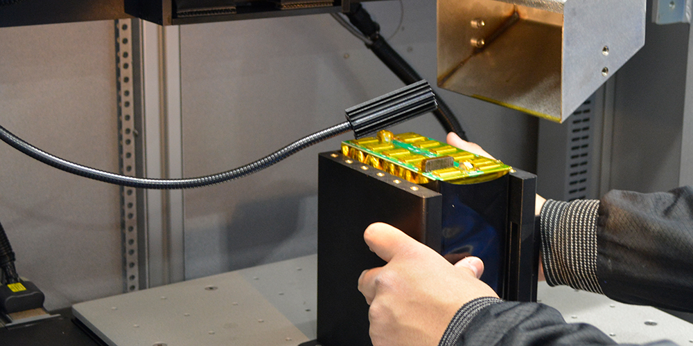 A pouch cell battery pack being set down for laser welding.