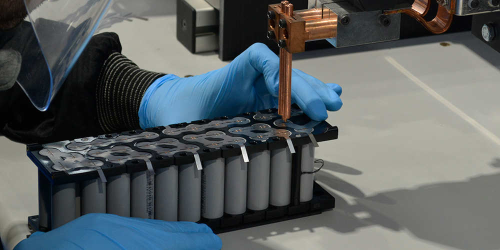 Cylindrical battery cells being welded.