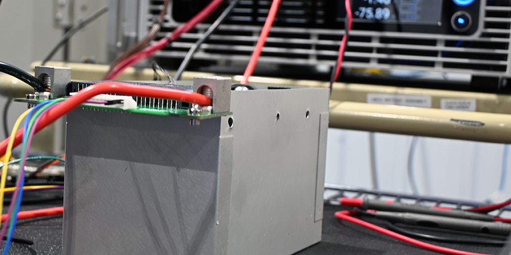 An unfinished battery pack wired to a testing unit.