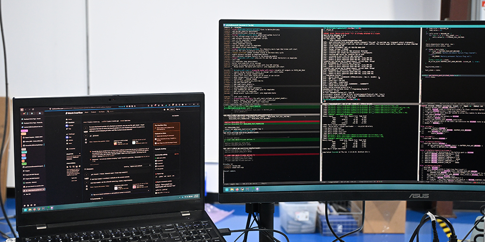 Computer monitors showing lines of text.